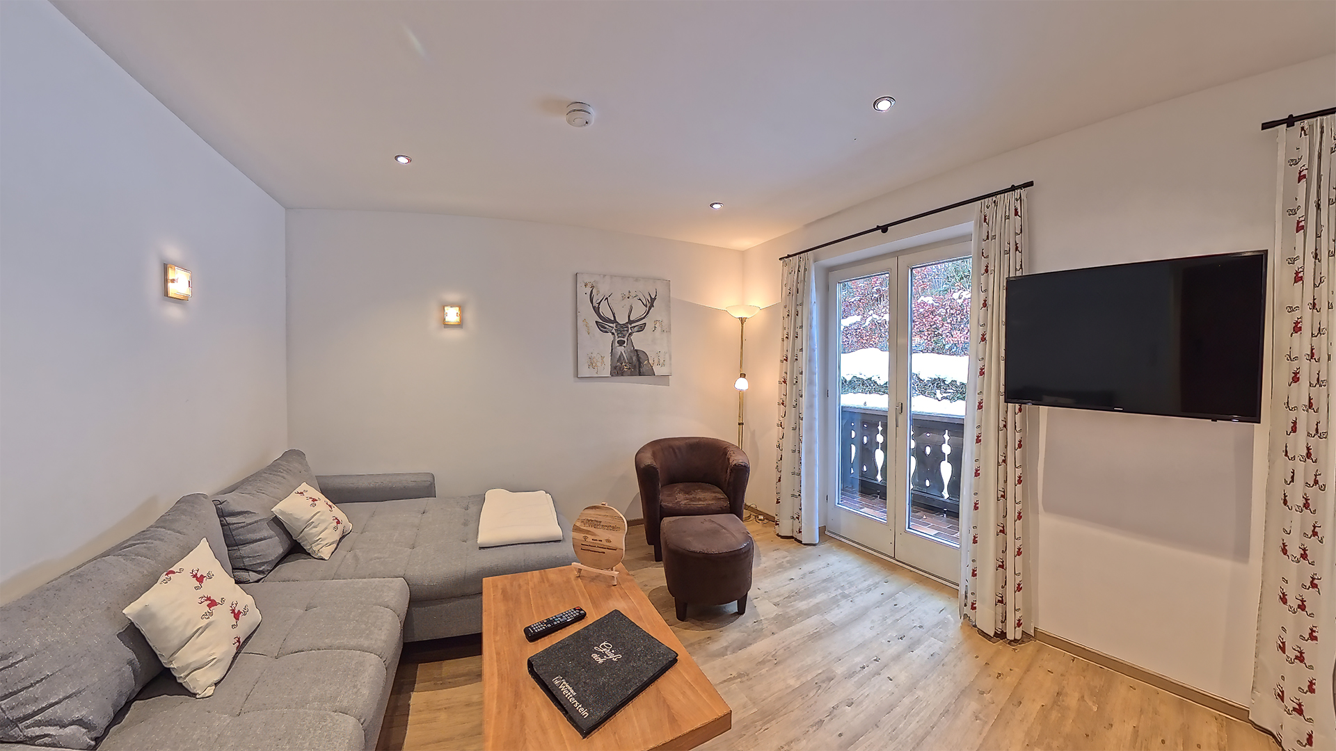 Der Wohnbereich mit Couch, Sessel, Tisch sowie Fernseher unserer Ferienwohnung "Waldblick" im Ferienhaus Wetterstein in Grainau direkt an der Zugspitze